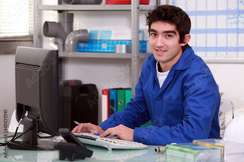 Photo: Plumber typing at a computer Plumber typing at a computer