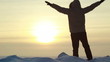 SLOW: Man poses on a summit at sunset and waves his arms