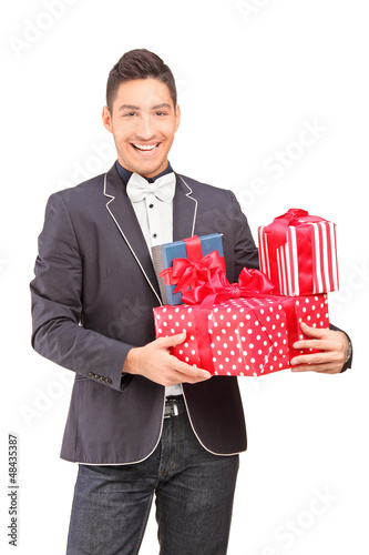Photo: A smiling handsome guy with bow tie holding presents A smiling handsome guy with bow tie holding presents