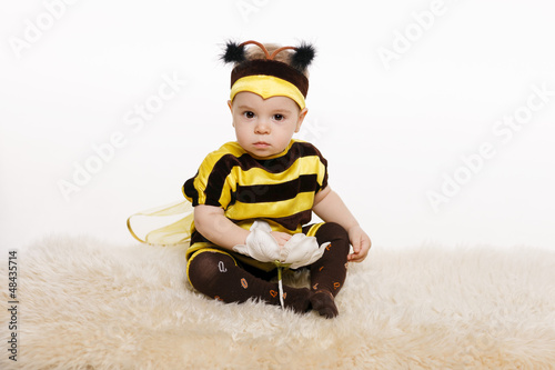 Photo: Baby wearing bee costume sitting on the floor Baby wearing bee costume sitting on the floor