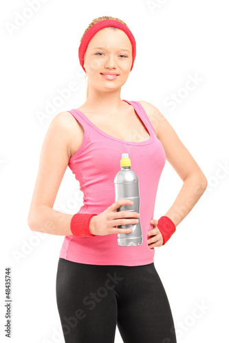Photo: Athletic young woman in sportswear holding a bottle of water Athletic young woman in sportswear holding a bottle of water