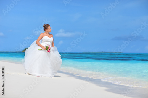 Photo: Bride watching towards the see on an exotic beach Bride watching towards the see on an exotic beach