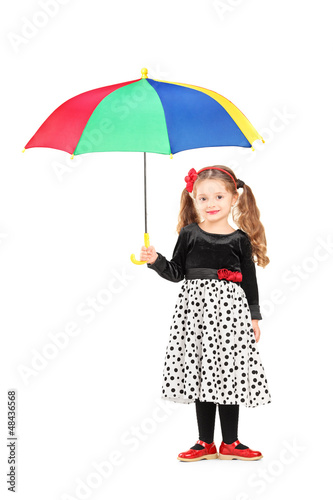 Photo: Full length portrait of a cute little girl holding a colorful um Full length portrait of a cute little girl holding a colorful um