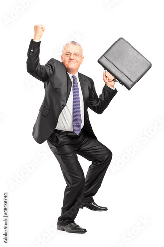 Photo: Happy mature businessperson with raised hands and briefcase Happy mature businessperson with raised hands and briefcase