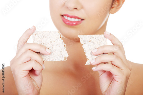 Photo: Young woman eating healthy rye cracker bread Young woman eating healthy rye cracker bread