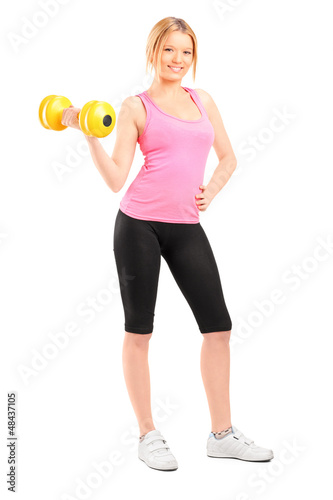 Photo: An attractive young woman lifting a dumbbell An attractive young woman lifting a dumbbell