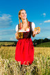 Junge Frau trinkt Bier und hält Brezel 