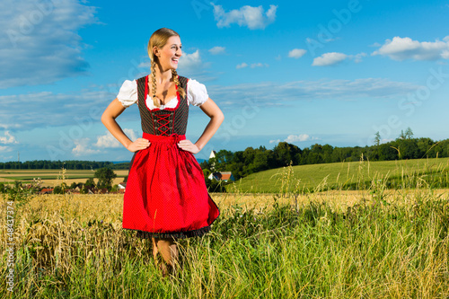 Photo: Junge Frau auf der Wiese und trägt Dirndl Junge Frau auf der Wiese und trägt Dirndl