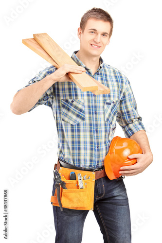 Photo: Smiling carpenter holding a helmet and sills Smiling carpenter holding a helmet and sills