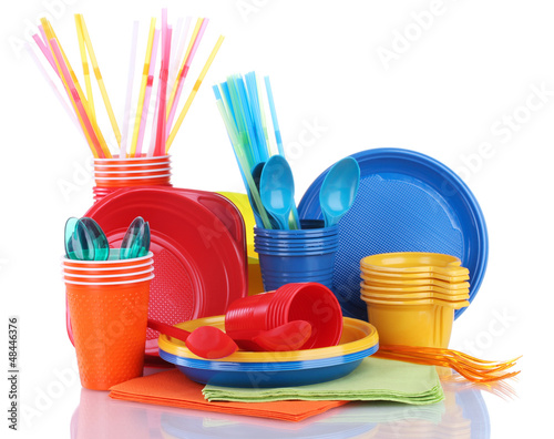 Photo: Bright plastic tableware and napkins isolated on white Bright plastic tableware and napkins isolated on white