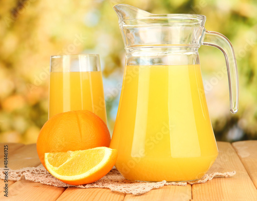 Photo: Full glass and jug of orange juice and oranges Full glass and jug of orange juice and oranges