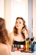 Portrait of attractive woman applying parfume