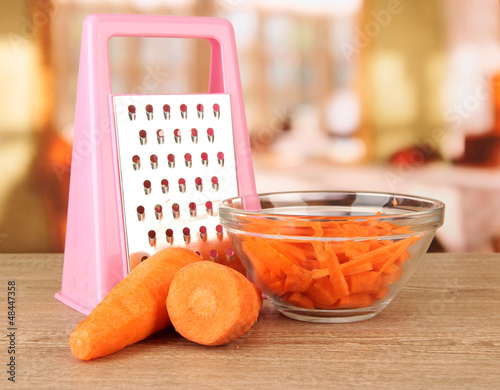 Photo: carrots with grater on table in kitchen carrots with grater on table in kitchen