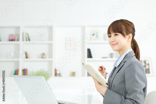 Photo: Beautiful young businesswoman working in office Beautiful young businesswoman working in office