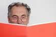 Senior beim Lesen oder Lernen mit einem Heft