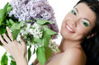 Photo: Beautiful woman with spring flowers of a lilac. Skincare Beautiful woman with spring flowers of a lilac. Skincare