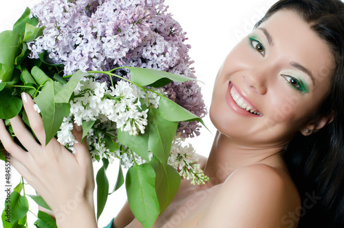 Photo: Beautiful woman with spring flowers of a lilac. Skincare Beautiful woman with spring flowers of a lilac. Skincare