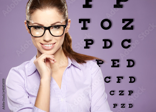 Photo: beautiful woman with trendy glasses on the background of eye te beautiful woman with trendy glasses on the background of eye te