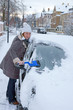 Photo: Woman remove snow from windshield Woman remove snow from windshield