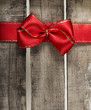 Red ribbon on old wooden background