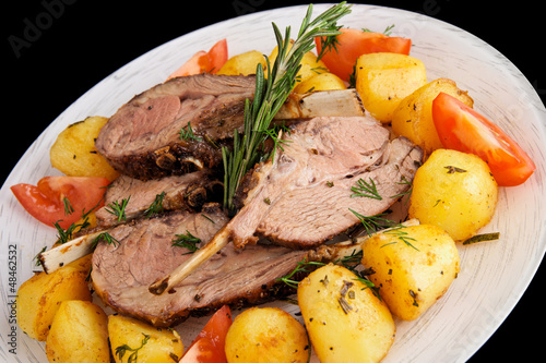 Photo: Rack of lamb with fried potatoes isolated on black Rack of lamb with fried potatoes isolated on black