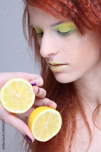 Photo: young redhaired girl with lemon. close up young redhaired girl with lemon. close up