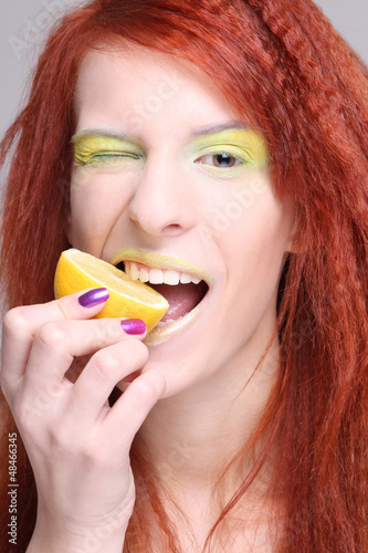 Photo: redhaired woman biting the lemon redhaired woman biting the lemon