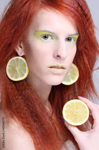 Photo: portrait of woman with lemon slices in ears portrait of woman with lemon slices in ears