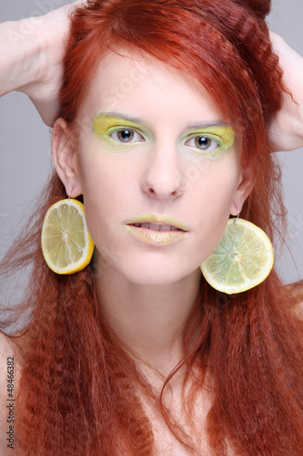 Photo: portrait of woman with lemon slices in ears portrait of woman with lemon slices in ears