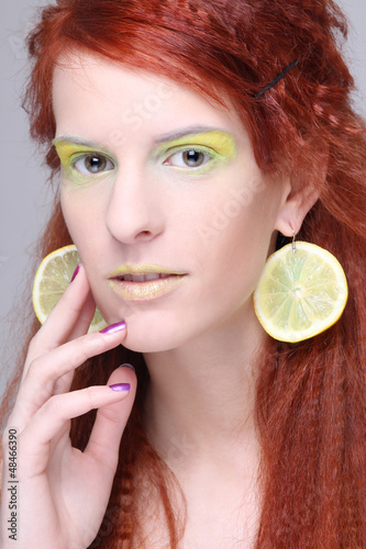 Photo: beautiful girl with lemon slices in ears beautiful girl with lemon slices in ears