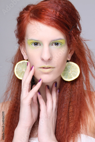 Photo: beautiful redhaired girl with lemon slices in ears beautiful redhaired girl with lemon slices in ears