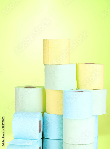 Photo: bright rolls of toilet paper on green background bright rolls of toilet paper on green background