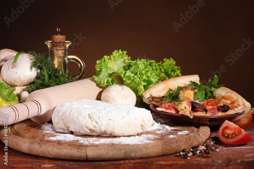 Photo: delicious pizza dough, spices and vegetables delicious pizza dough, spices and vegetables