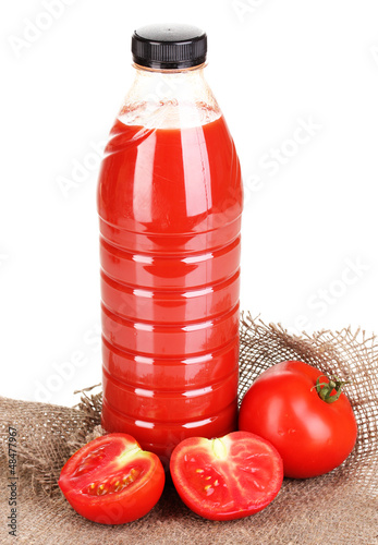 Photo: Tomato juice in bottle on sackcloth isolated on white Tomato juice in bottle on sackcloth isolated on white