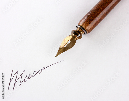 Photo: Closeup of signature (fake, not real) and ink pen, isolated Closeup of signature (fake, not real) and ink pen, isolated