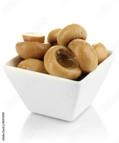 Photo: Delicious marinated mushrooms in bowl isolated on white Delicious marinated mushrooms in bowl isolated on white
