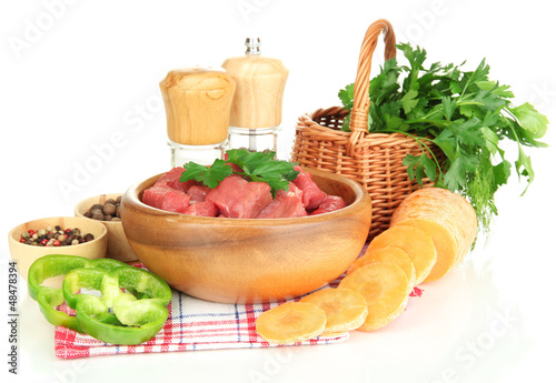 Photo: Raw beef meat in bowl with herbs and spices isolated on white Raw beef meat in bowl with herbs and spices isolated on white
