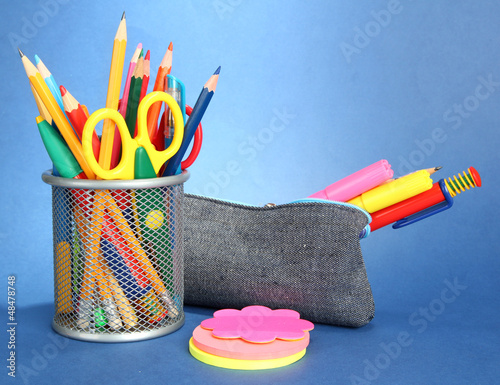 Photo: pencil box with school equipment on blue background pencil box with school equipment on blue background