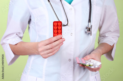 Photo: Close-up of female doctor hand holding pills, Close-up of female doctor hand holding pills,