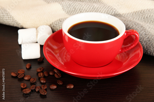 Photo: cup of coffee with scarf on table in room cup of coffee with scarf on table in room