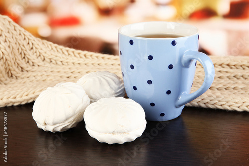 Photo: cup of tea with scarf on table in room cup of tea with scarf on table in room