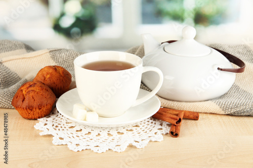 Photo: cup of tea with scarf on table in room cup of tea with scarf on table in room
