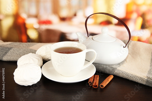 Photo: cup of tea with scarf on table in room cup of tea with scarf on table in room