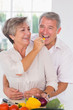 Woman feeding pepper to man