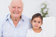 Granddaughter and grandfather sitting on the sofa