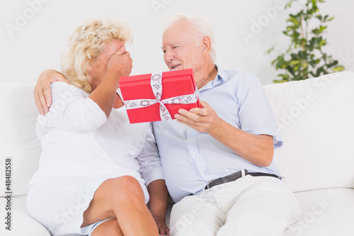Photo: Old man offering a gift to the elderly woman Old man offering a gift to the elderly woman