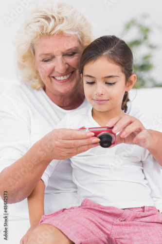 Photo: Granddaughter and grandmother looking at pictures Granddaughter and grandmother looking at pictures