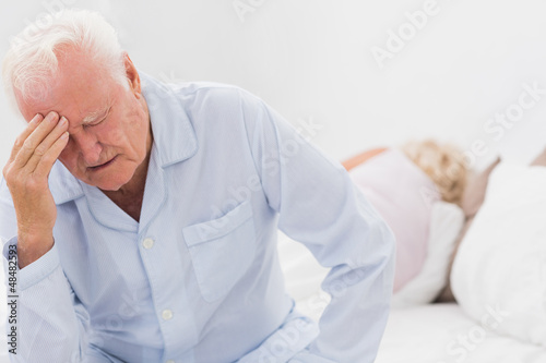 Photo: Old man suffering while woman sleeping Old man suffering while woman sleeping