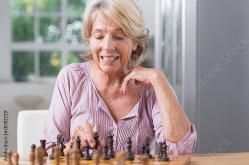 Photo: Mature woman playing chess Mature woman playing chess