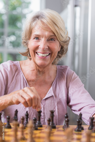 Photo: Happy woman playing chess Happy woman playing chess